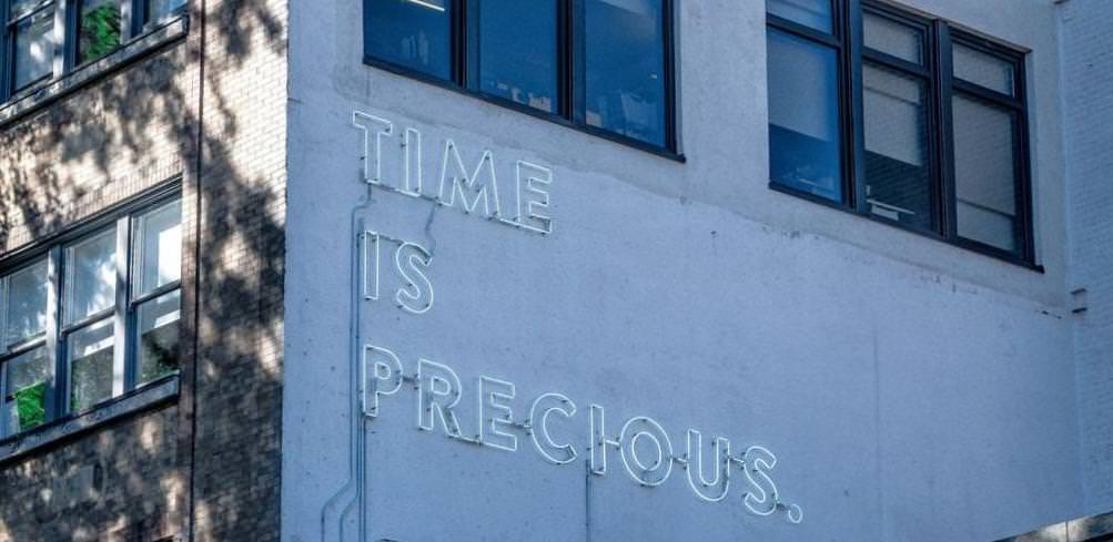 a neon sign saying 'time is precious'